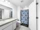 Bright bathroom featuring a granite countertop, white cabinetry, and a shower with a stylish blue curtain at 532 Madison Dr, Davenport, FL 33837