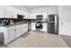 Modern kitchen featuring white cabinets, granite countertops, stainless steel appliances, and black tile backsplash at 532 Madison Dr, Davenport, FL 33837