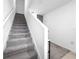 Carpeted staircase features a white handrail with a neutral color, and a landing leading to the upper level at 532 Madison Dr, Davenport, FL 33837