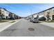 Scenic neighborhood street lined with modern townhomes, featuring well-kept landscaping and parked cars at 532 Madison Dr, Davenport, FL 33837