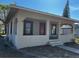 Single-story house featuring a covered porch, a red front door, and horizontal siding at 542 N 8Th St, Eagle Lake, FL 33839