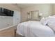 Bedroom with plush carpet, mounted TV, white bedding, and natural light at 7517 Laureate Blvd # 4103, Orlando, FL 32827