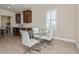 Bright dining area with white chairs and glass table adjacent to kitchen space at 7517 Laureate Blvd # 4103, Orlando, FL 32827