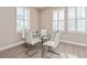 Chic dining area with a glass table, modern white chairs, and plenty of natural light at 7517 Laureate Blvd # 4103, Orlando, FL 32827