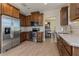 Well-lit kitchen with stainless steel appliances, wooden cabinets, and marble countertops at 7517 Laureate Blvd # 4103, Orlando, FL 32827