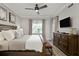 Bedroom featuring wood floors, an upholstered bench, and a ceiling fan at 7651 Whisper Way # 204, Reunion, FL 34747