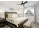 Bright bedroom featuring a ceiling fan, window with sheer curtains, wood flooring, and a neutral color palette at 7651 Whisper Way # 204, Reunion, FL 34747