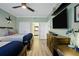 View of a well-lit bedroom featuring a television, beds, and an ensuite bathroom at 7651 Whisper Way # 204, Reunion, FL 34747