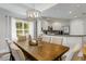 Dining area features a wooden table, upholstered chairs, and natural light through a window at 7651 Whisper Way # 204, Reunion, FL 34747