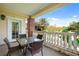 The patio has a glass table and chairs with a brick column and a view of the green landscaping at 7651 Whisper Way # 204, Reunion, FL 34747