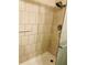 Tiled shower stall with safety bar, adjustable shower head, and glass door at 7706 Country Pl # 7706, Winter Park, FL 32792