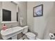 Elegant powder room with a pedestal sink, stylish mirror, and neutral wall color at 807 Oak Shadows Rd, Celebration, FL 34747