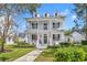 Charming two-story home featuring a spacious double porch, complemented by well-manicured landscaping and a welcoming walkway at 807 Oak Shadows Rd, Celebration, FL 34747