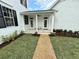 Inviting front porch with rocking chairs and a beautifully landscaped walkway leading to the entrance at 807 Oak Shadows Rd, Celebration, FL 34747