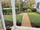 Beautifully landscaped front yard with manicured lawn, mulch beds, and iron fence and gate at 807 Oak Shadows Rd, Celebration, FL 34747