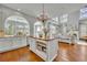 Bright, open kitchen featuring white cabinets, a wooden island, and seamless flow into the living area at 807 Oak Shadows Rd, Celebration, FL 34747