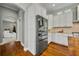 Contemporary kitchen with white cabinets, stone backsplash, stainless steel refrigerator, and hardwood floors at 807 Oak Shadows Rd, Celebration, FL 34747