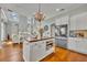 Open-concept kitchen with an island, chandelier, stainless steel refrigerator, and view to the living area at 807 Oak Shadows Rd, Celebration, FL 34747