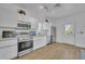 Modern kitchen featuring stainless steel appliances, white cabinetry, light wood flooring and ample counter space at 807 Oak Shadows Rd, Celebration, FL 34747