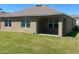 Backyard showing lawn, covered patio, and a view of the home's exterior at 956 Brooklet Dr, Davenport, FL 33837