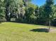 Fenced backyard featuring a large grassy area with mature trees, offering a private outdoor space at 956 Brooklet Dr, Davenport, FL 33837