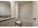 Bright bathroom featuring a granite vanity top, tiled floors, and a shower-tub combo at 956 Brooklet Dr, Davenport, FL 33837