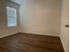 Comfortable bedroom featuring sleek wood flooring, a window, and a light neutral color palette at 956 Brooklet Dr, Davenport, FL 33837