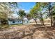 Large backyard with a blue house with a fenced perimeter and mature trees at 1117 N Hart Blvd, Orlando, FL 32818