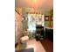 A bathroom with a curtained window, white toilet with floral pattern, shelving unit, and vanity at 11213 River Grove Dr, Orlando, FL 32817