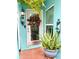 Close up of the front door that features a decorative wreath, sidelight, and potted plant at 11213 River Grove Dr, Orlando, FL 32817