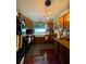 A kitchen with a black refrigerator, light fixtures, wooden cabinets, and a white farmhouse style sink at 11213 River Grove Dr, Orlando, FL 32817