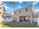 A covered patio area with seating and a hot tub overlooking the grassy backyard at 1129 Blue Garden Dr, Deland, FL 32720