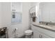 Bright powder room with a single sink vanity, white cabinets, and a storage unit at 1129 Blue Garden Dr, Deland, FL 32720