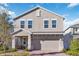Charming two-story home featuring a covered front porch, a two-car garage, and manicured landscaping at 1129 Blue Garden Dr, Deland, FL 32720