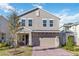 Charming two-story home boasts neutral stucco, stone accents, brick driveway and a welcoming covered front porch at 1129 Blue Garden Dr, Deland, FL 32720