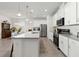Bright kitchen features white cabinets, stainless steel appliances, pendant lighting, and a large center island at 1129 Blue Garden Dr, Deland, FL 32720
