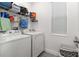 Efficient laundry room with a washer, dryer, shelving for storage, and a window for natural light at 1129 Blue Garden Dr, Deland, FL 32720