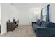 Sitting area features a desk with a chair, a comfortable blue couch, carpet floors, and natural light at 1129 Blue Garden Dr, Deland, FL 32720