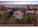 Aerial view of a beautiful home with a pool, lush greenery, and waterfront views at twilight at 11306 Bridge House Rd, Windermere, FL 34786