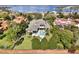 Aerial view of a luxury home with a pool, surrounded by lush landscaping and mature trees, near a lake at 11306 Bridge House Rd, Windermere, FL 34786