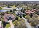 Stunning aerial shot of a grand home near a lake and golf course, with mature trees and neighboring properties at 11306 Bridge House Rd, Windermere, FL 34786