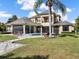 Expansive backyard with pool, patio, lush landscaping, and an elegant home exterior at 11306 Bridge House Rd, Windermere, FL 34786