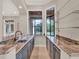 Elegant bar area with granite countertops, dark cabinets, and glass shelving at 11306 Bridge House Rd, Windermere, FL 34786