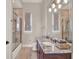 Bright bathroom features vanity with stone counters and frameless shower at 11306 Bridge House Rd, Windermere, FL 34786