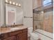 Well-lit bathroom with granite vanity, glass shower door, and mosaic tile accents at 11306 Bridge House Rd, Windermere, FL 34786