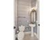 Charming half bathroom featuring a pedestal sink, toilet, decorative mirror and wallpaper at 11306 Bridge House Rd, Windermere, FL 34786