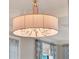 A close up of an elegant hanging chandelier with a fabric lampshade in the bedroom at 11306 Bridge House Rd, Windermere, FL 34786