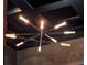Modern starburst chandelier with linear lights against a dark ceiling at 11306 Bridge House Rd, Windermere, FL 34786