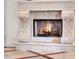Ornate fireplace with carved stone and a warm fire creates a cozy and inviting focal point in the home at 11306 Bridge House Rd, Windermere, FL 34786
