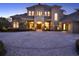 A luxurious home boasts a circular driveway and classic architectural design with warm inviting lights at 11306 Bridge House Rd, Windermere, FL 34786